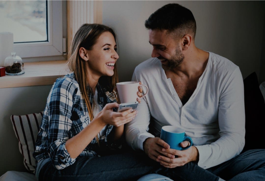 A couple at home choosing a RedSpeed mobile plan together on a phone
